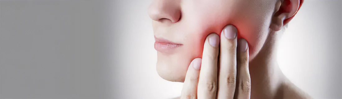 Dentist Tuscaloosa AL Emergency Dental woman with mouth pain holding her hand up to her jaw as it seems inflamed and painful